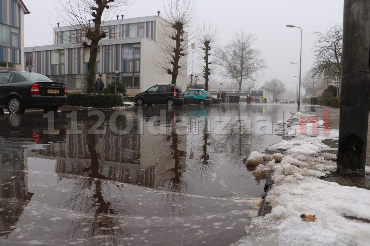 Foto: Waterleiding geknapt in Oldenzaal; straat onder water