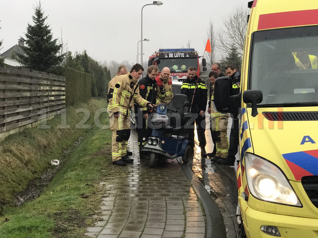 Foto: Scootmobiel belandt in sloot De Lutte, brandweer rukt uit