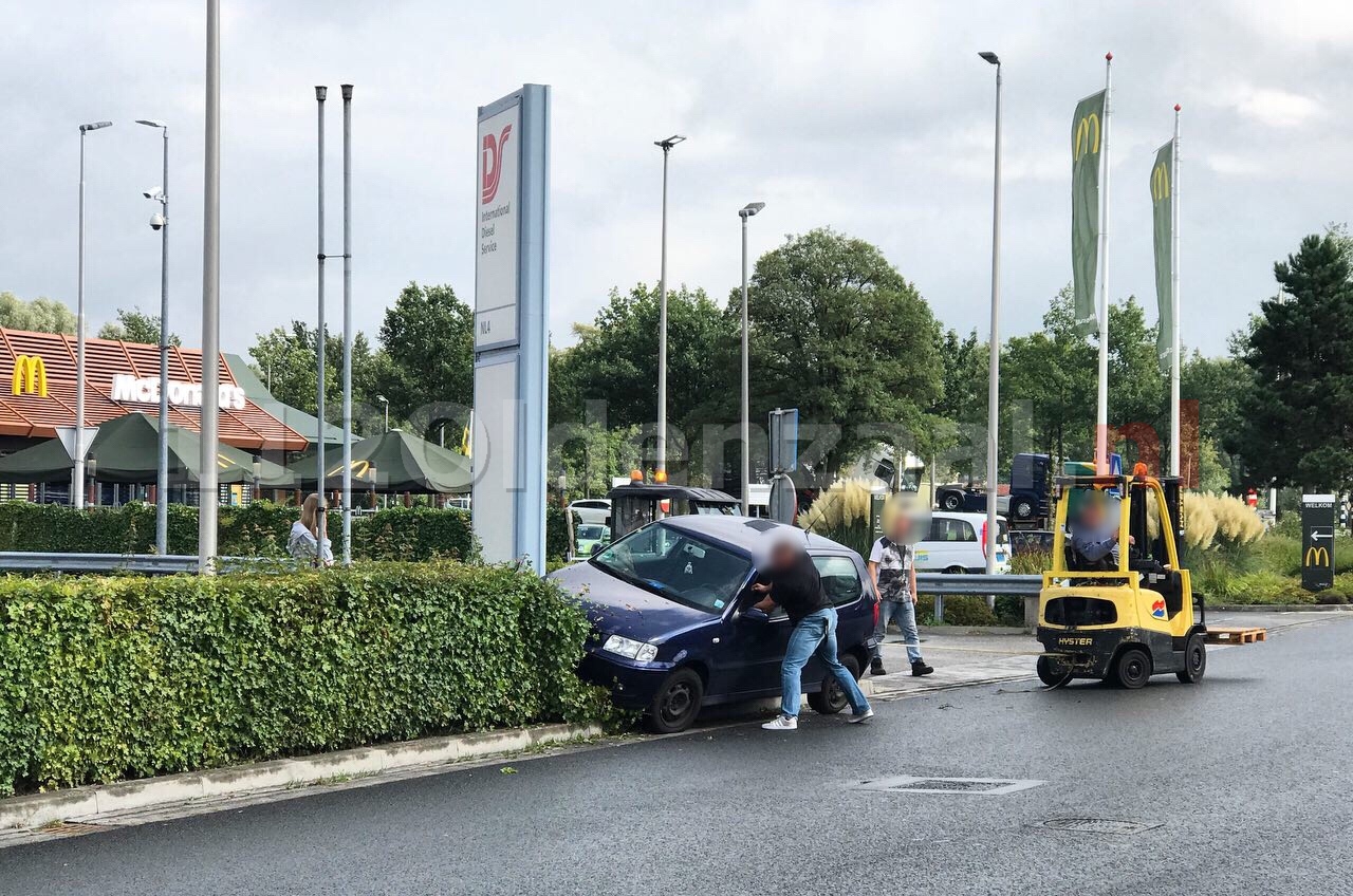 Vrouw rijdt met auto de bosjes in